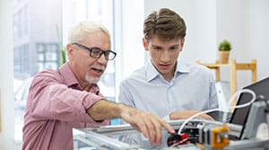 Man explaining something to trainee on a machine