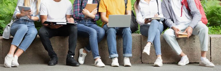 Pupils sit next to each other on a wall