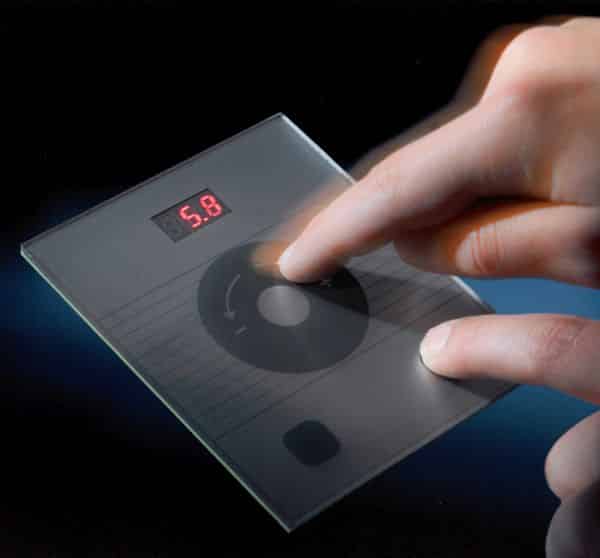 "A picture of a portable communication device with a person making a gesture with their finger. The device displays writing and is equipped with audio devices. It symbolizes modern technology and communication."