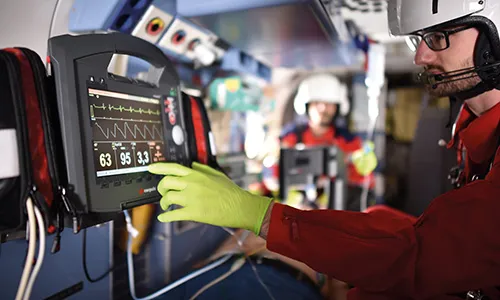 Paramedic operates defibrillator in helicopter