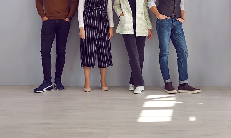 Employees stand side by side leaning against wall