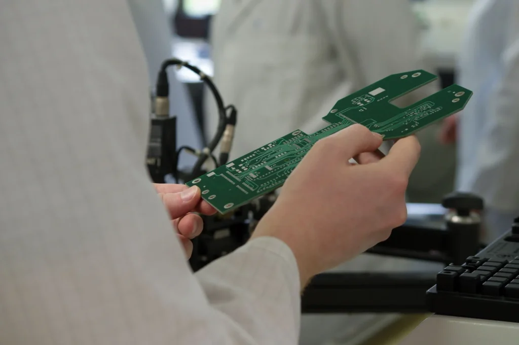 Employee holds printed circuit board in hand