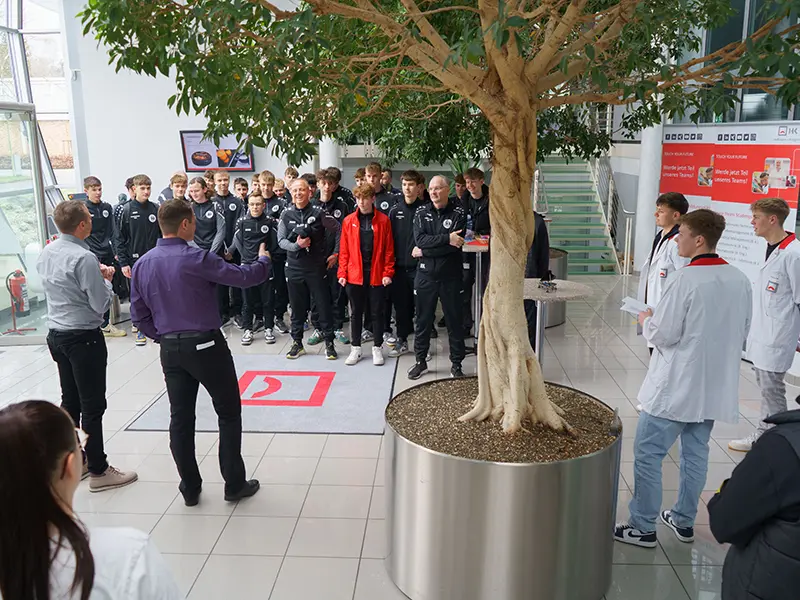 Managing Director gives a speech to the Hettingen soccer team in the foyer at Hoffmann + Krippner