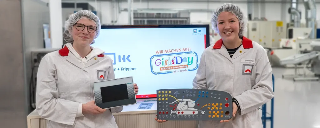 Two girls on Girls'Day hold a membrane keyboard in their hands