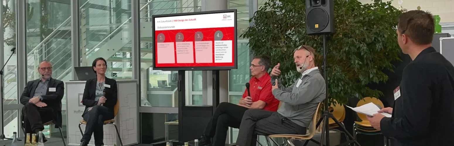 Four people sit on a stage and discuss